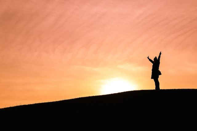 Woman throwing arms in air